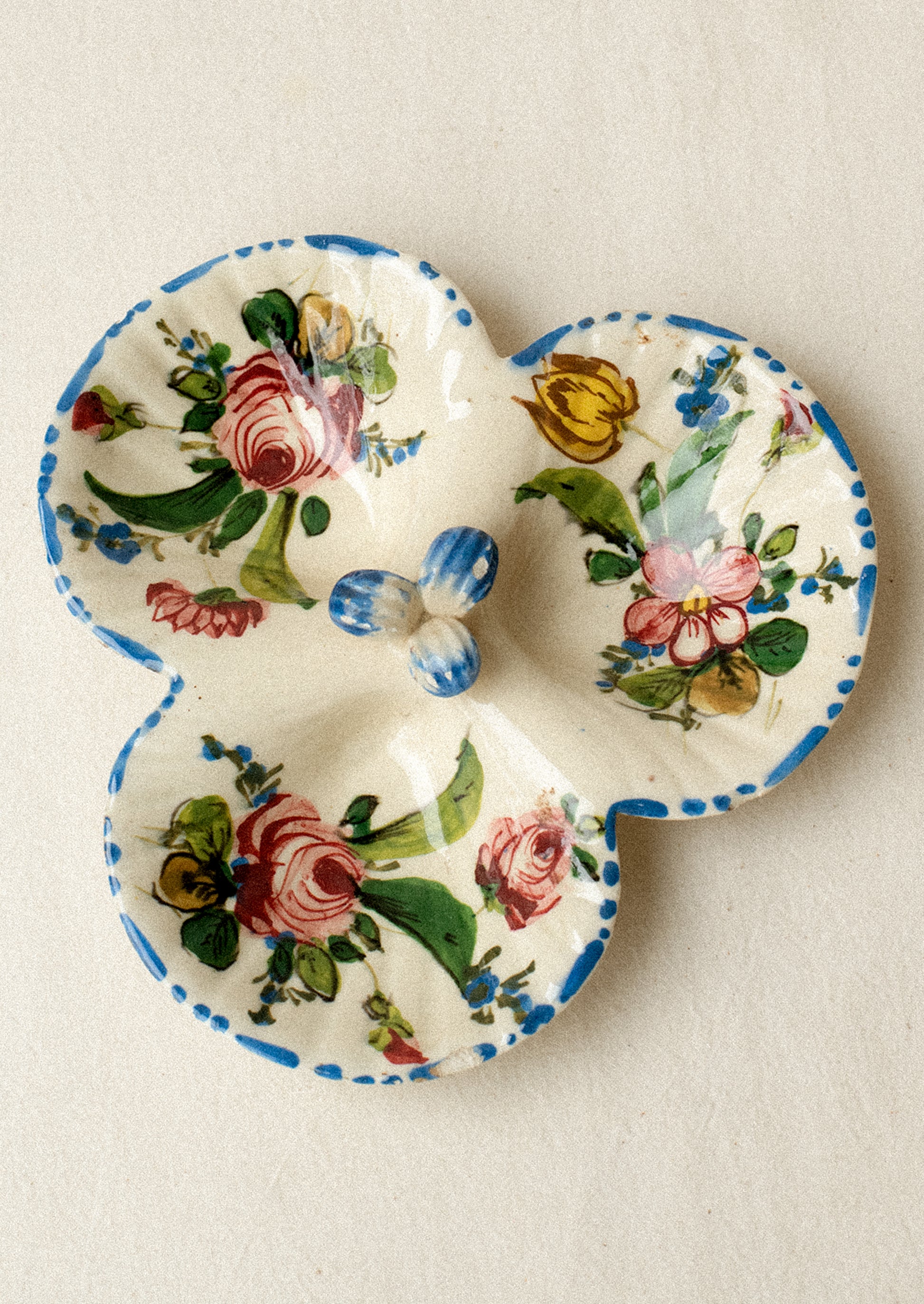 A triple well ceramic dish with hand painted floral pattern.
