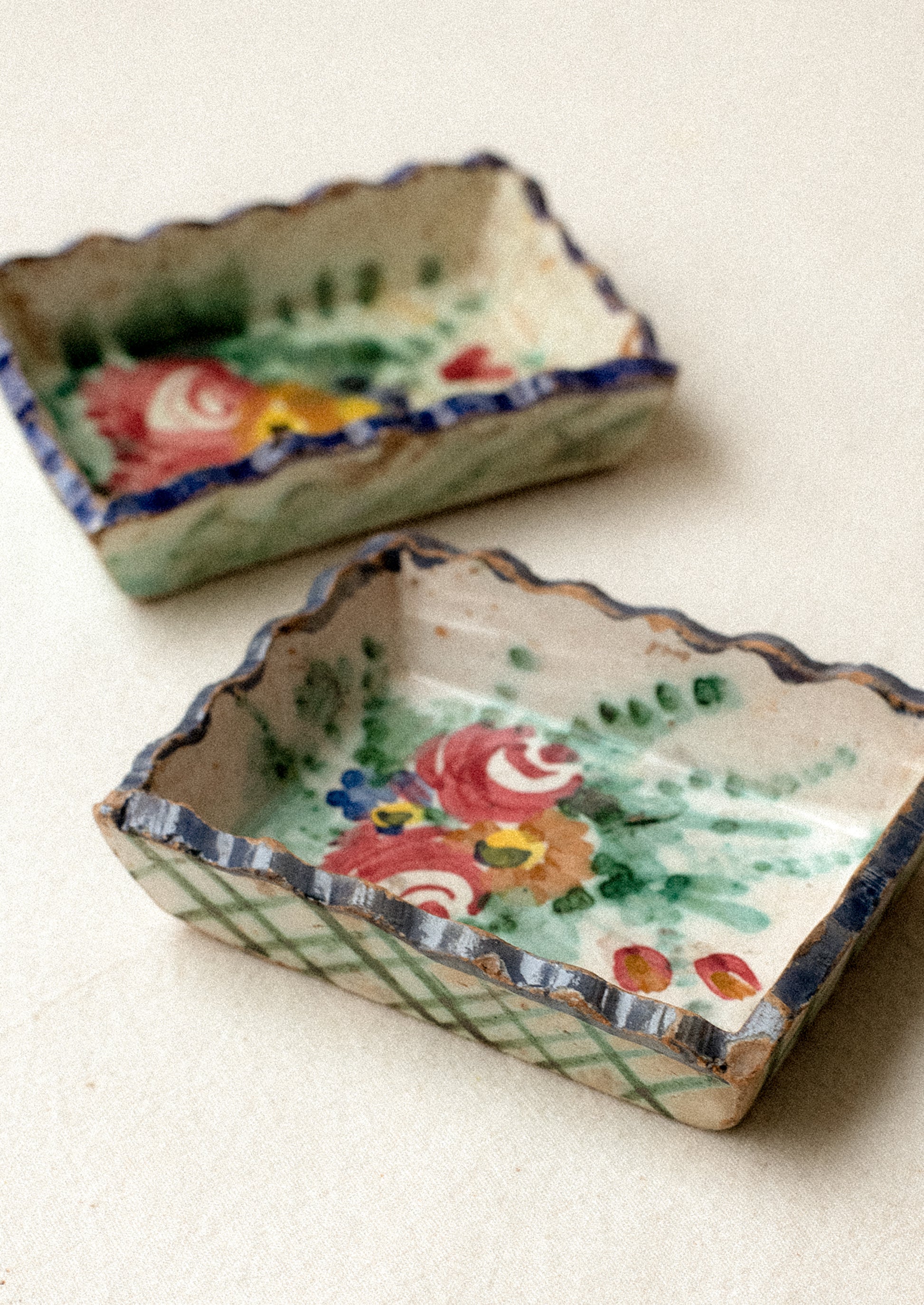 Two small rectangular ceramic trays with floral designs.