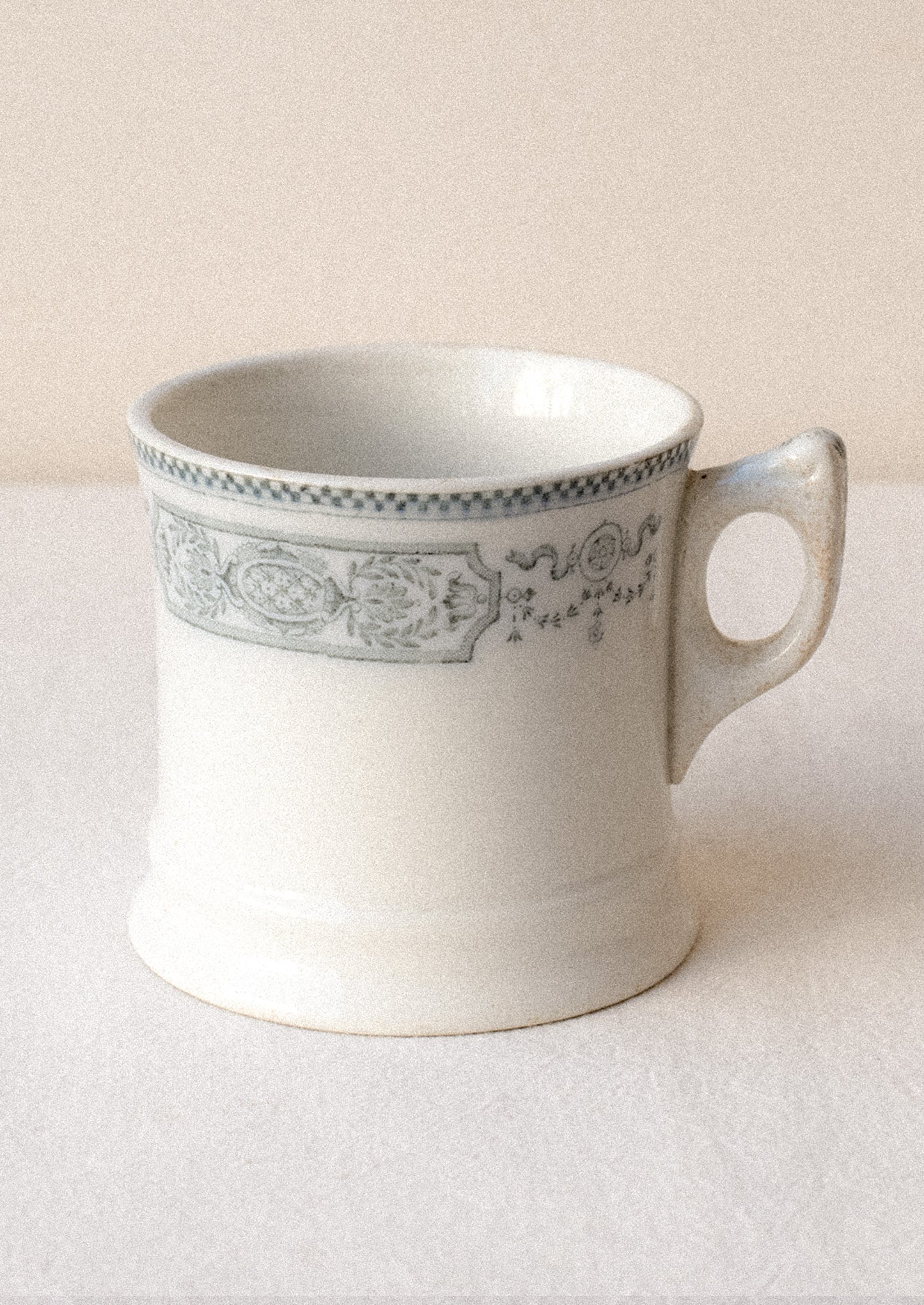 An antique English transferware mug with checkered lace pattern.