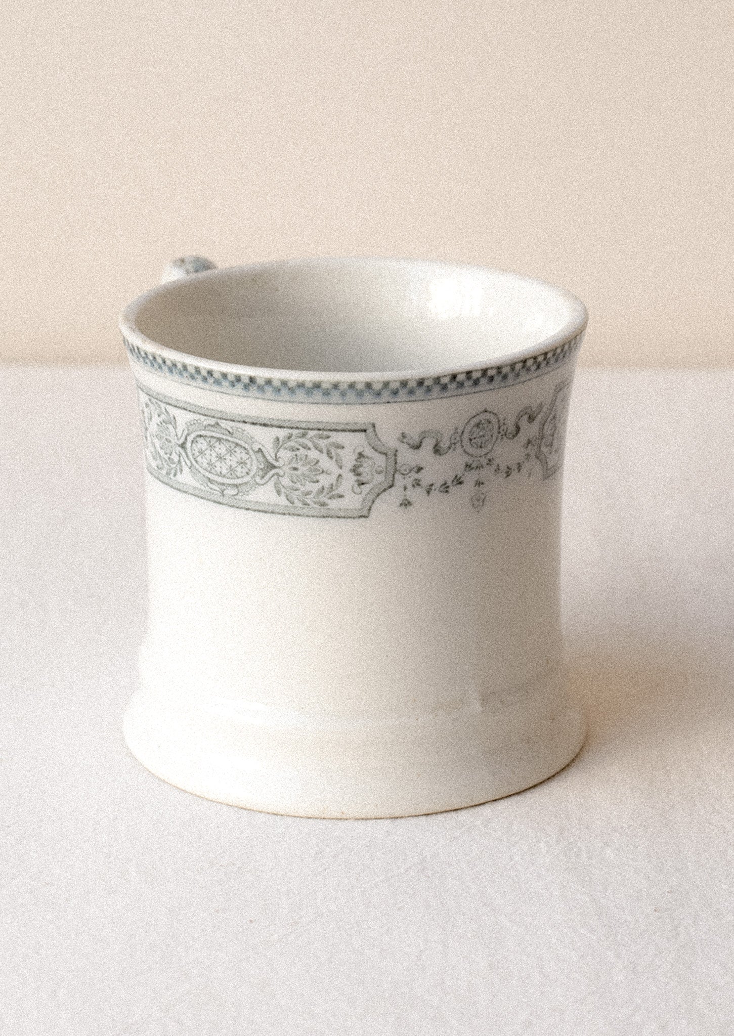 An antique English transferware mug with checkered lace pattern.