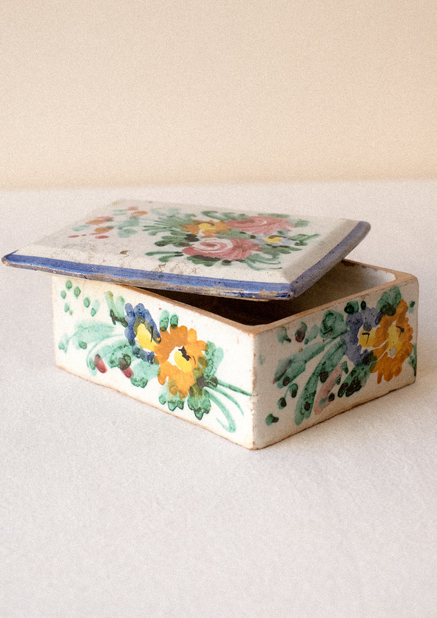 Decorative ceramic box with floral patterns on a plain background