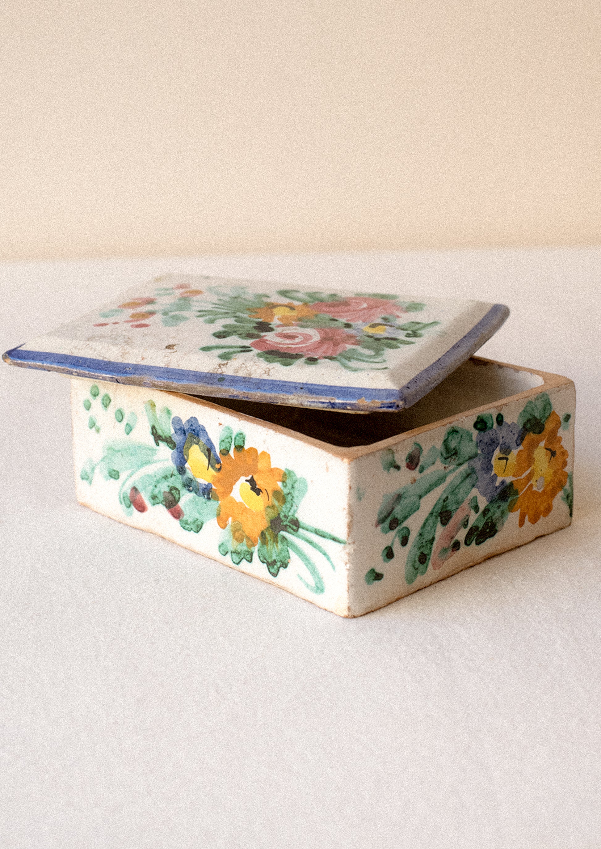 Decorative ceramic box with floral patterns on a plain background