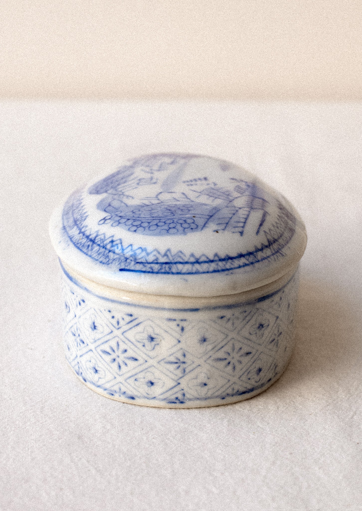A blue and white chinoiserie patterned lidded ceramic box.