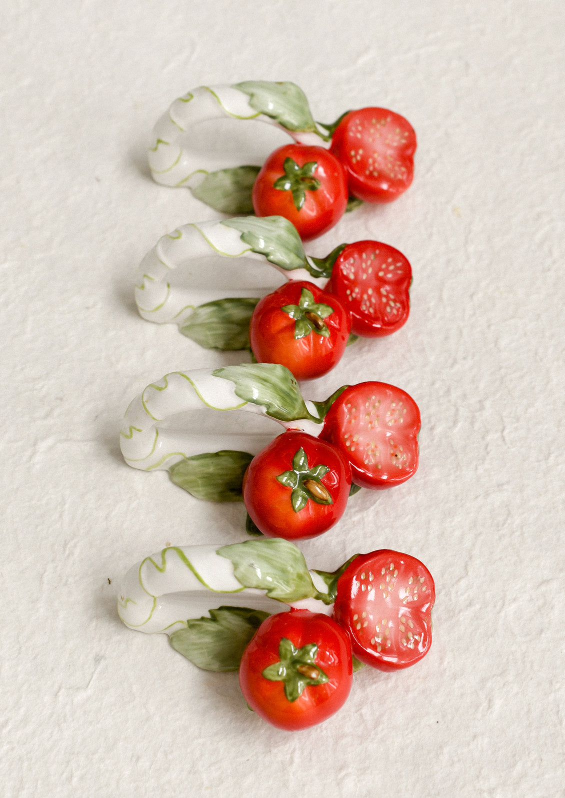 A set of 4 napkin rings with tomato motif.