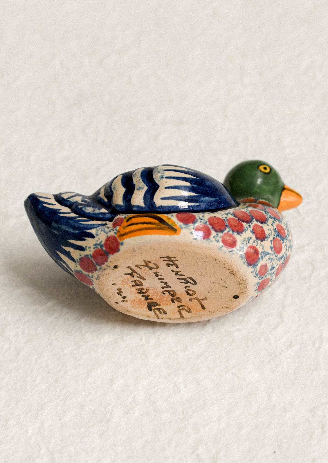 A hand-painted egg cup in the shape of a duck.