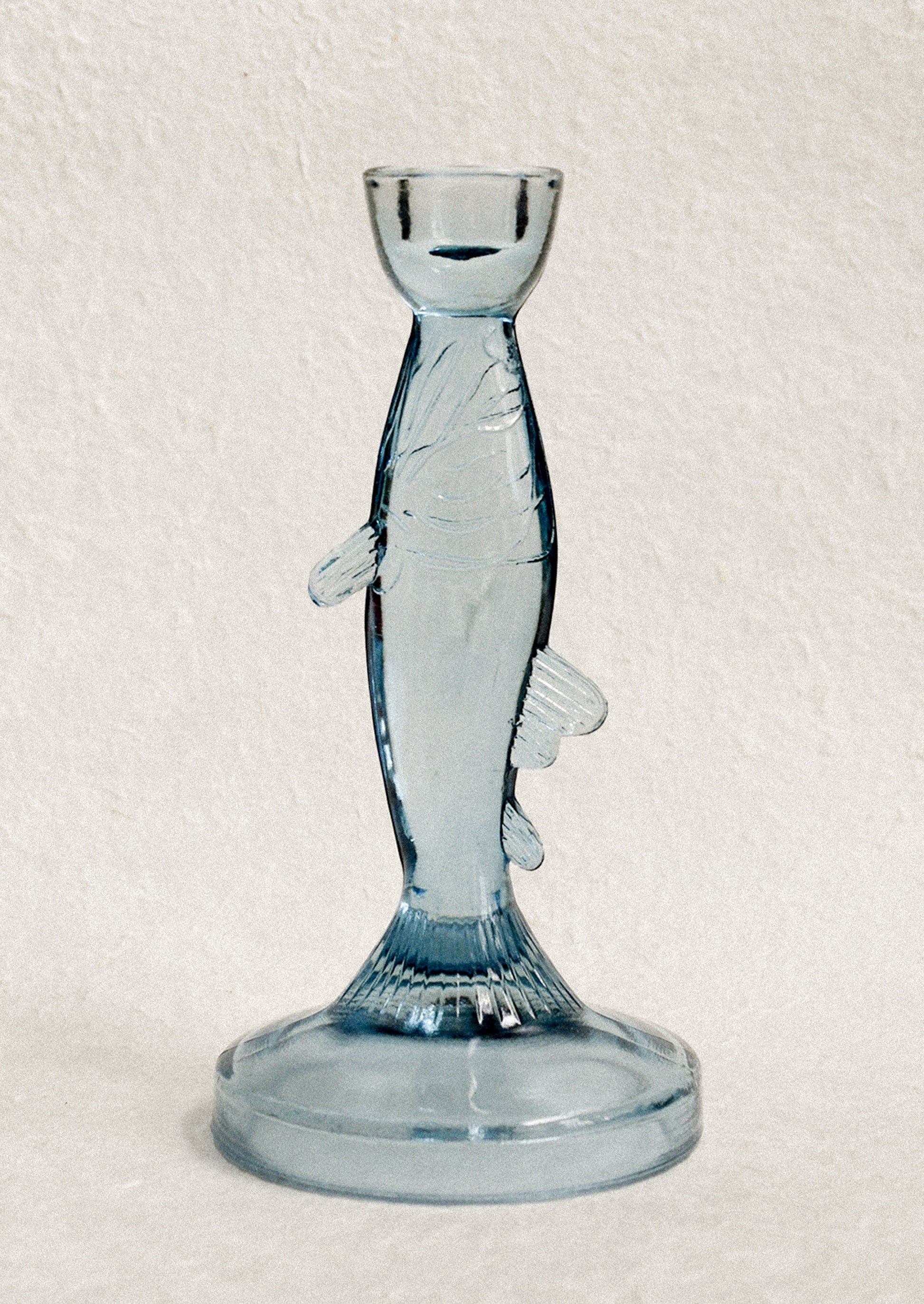 Blue glass candle holder shaped like a fish.