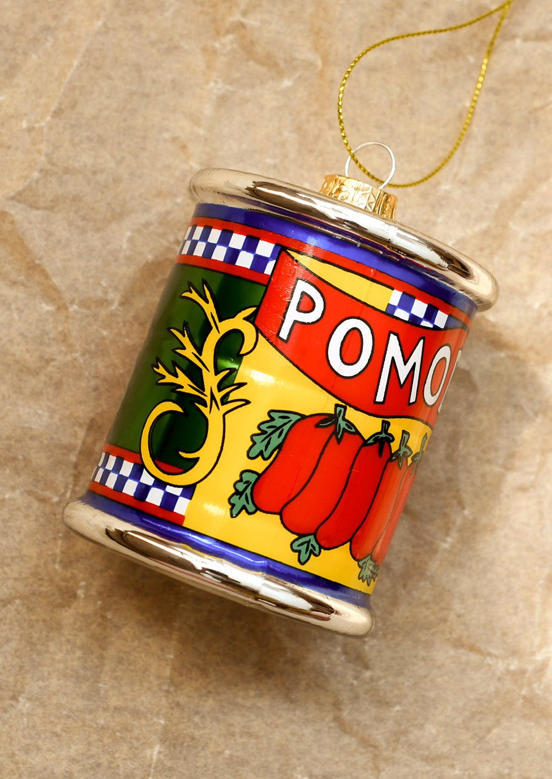 Decorative can ornament with tomato design on a textured beige background.