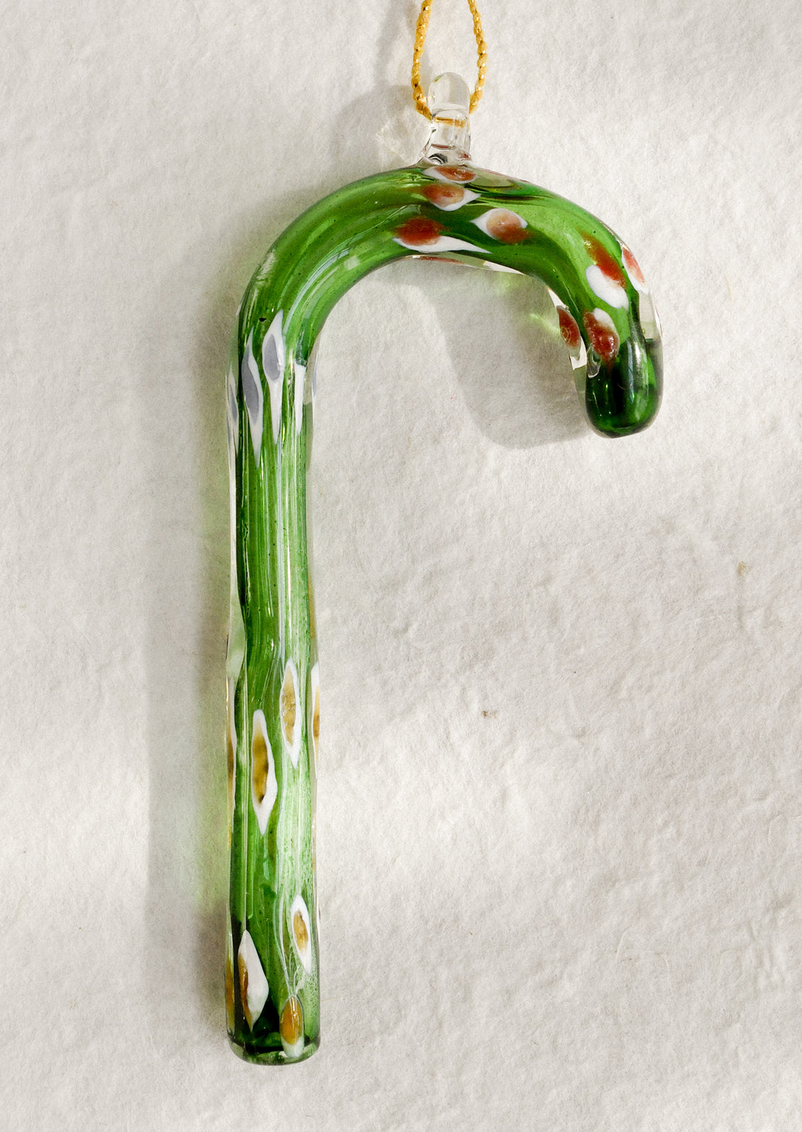 Decorative glass candy cane ornament on a white background