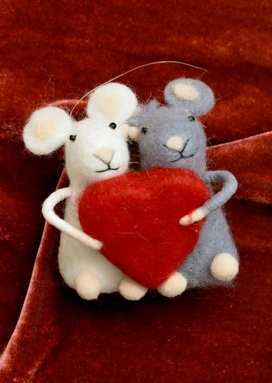 A felted holiday ornament of a white mouse and a gray mouse holding a red heart.