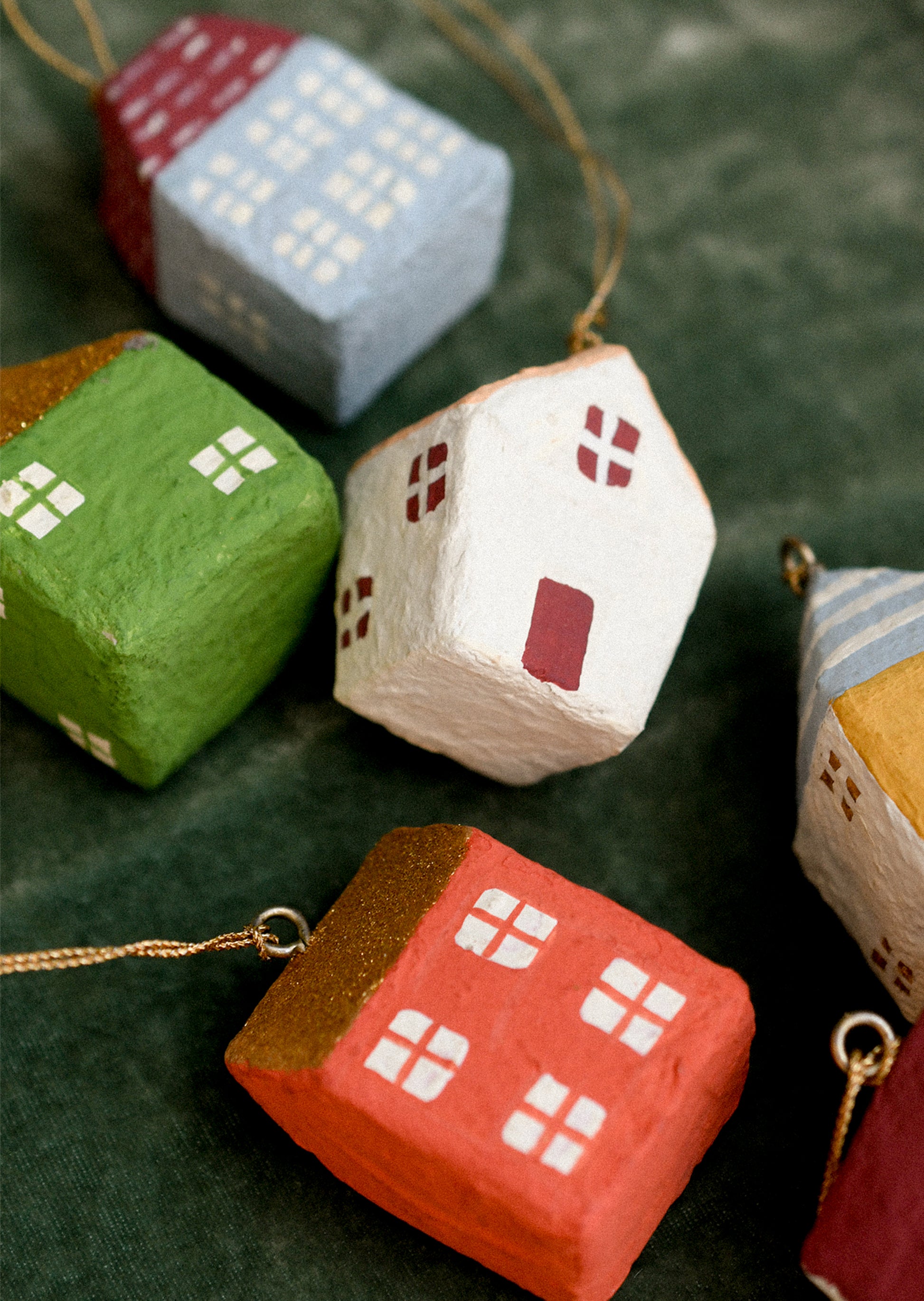 Colorful house-shaped ornaments on a dark green background