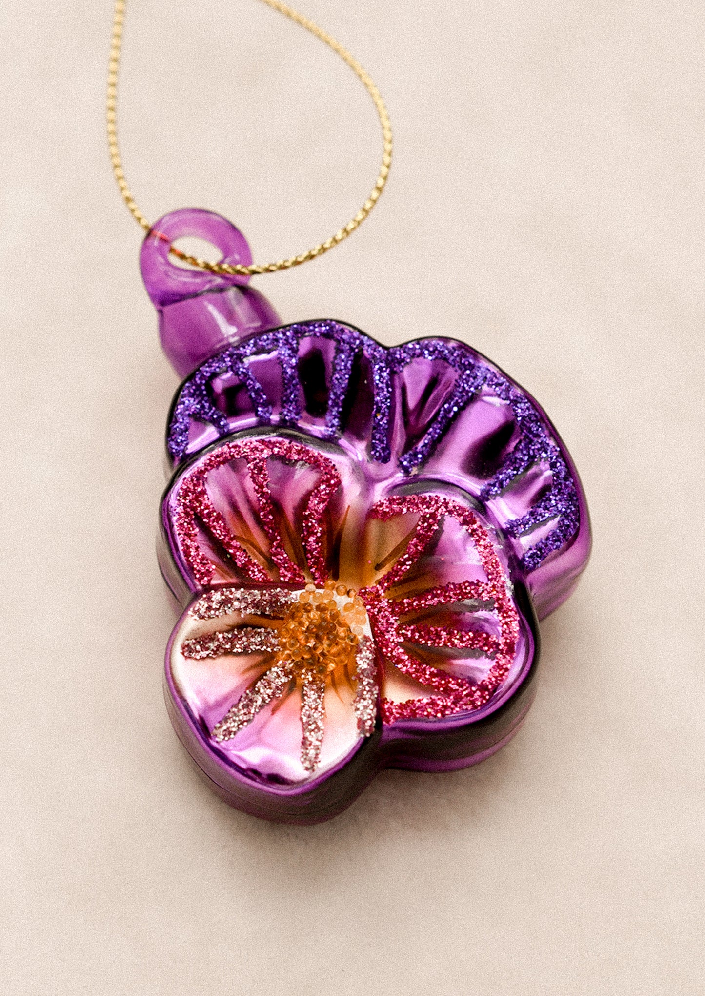 A glass ornament in the shape of a wild pansy flower.