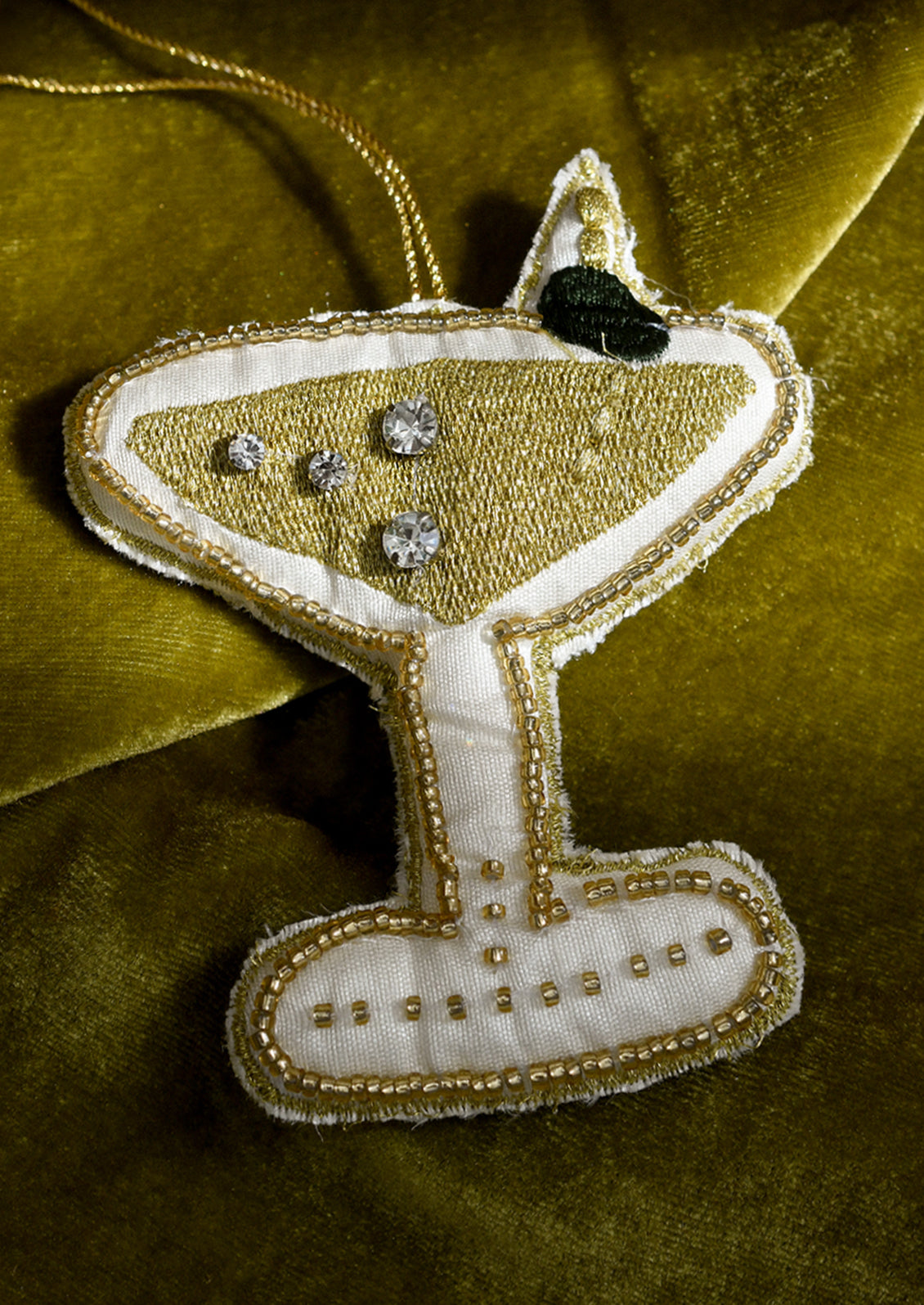 Decorative ornament shaped like a martini glass with beads on a green background