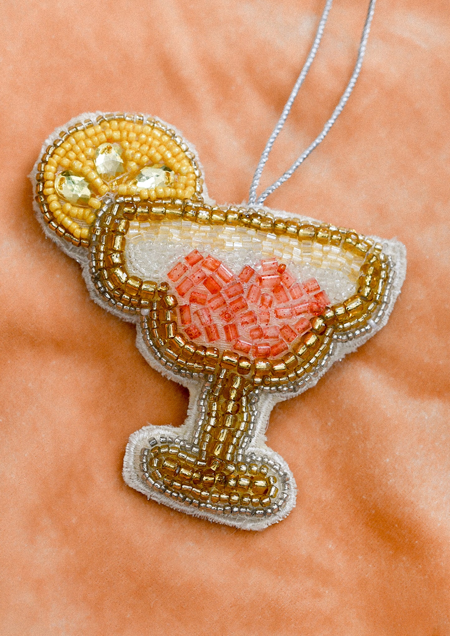 A decorative ornament in the shape of a daiquiri with beaded embellishment.