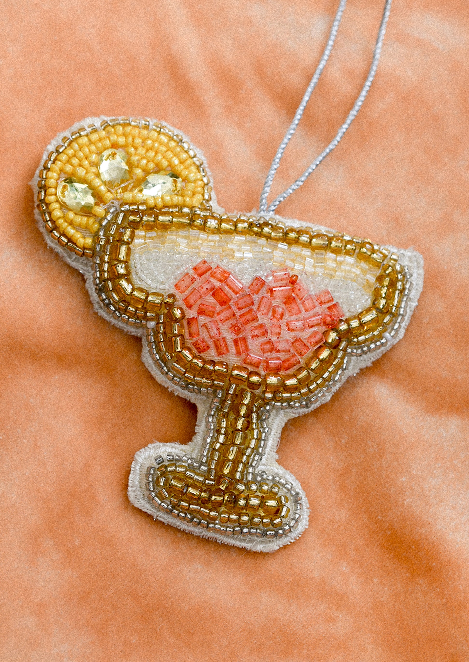 A decorative ornament in the shape of a daiquiri with beaded embellishment.