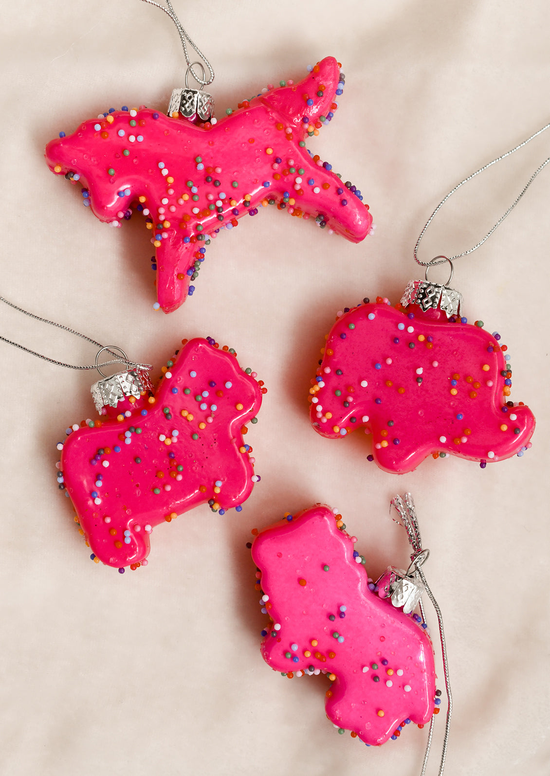 Ornaments that look like pink frosted animal cookies with confetti sprinkles.