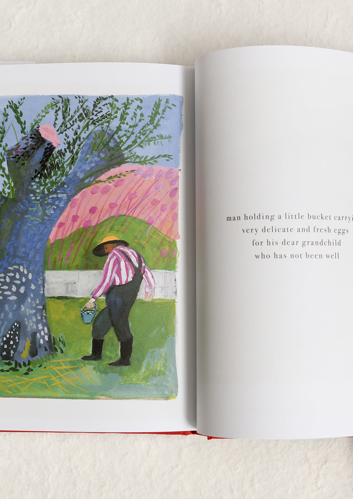 Open book with a colorful illustration of a man with a pink umbrella and a child, on a light background.