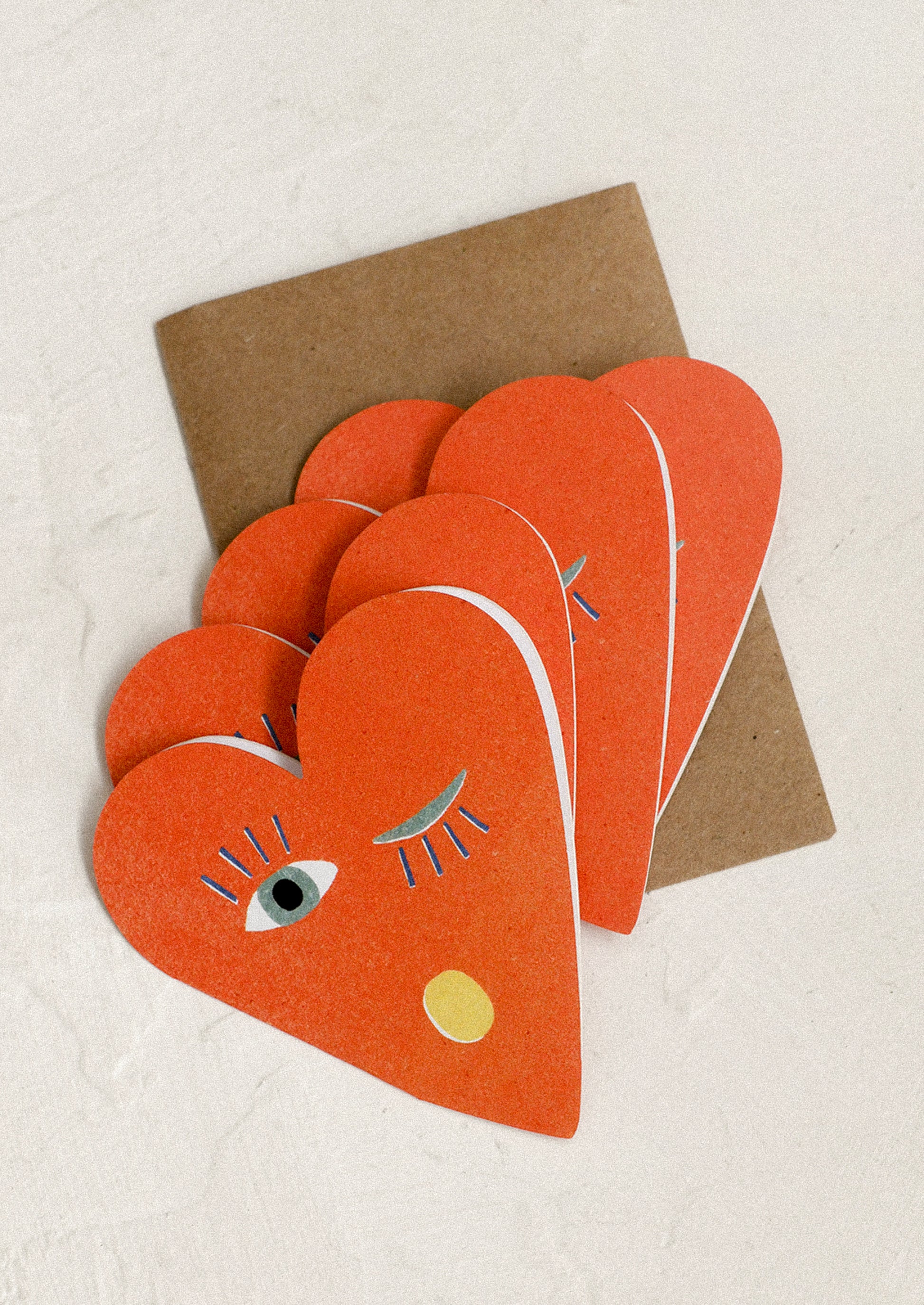 Set of red heart-shaped cards with face designs.
