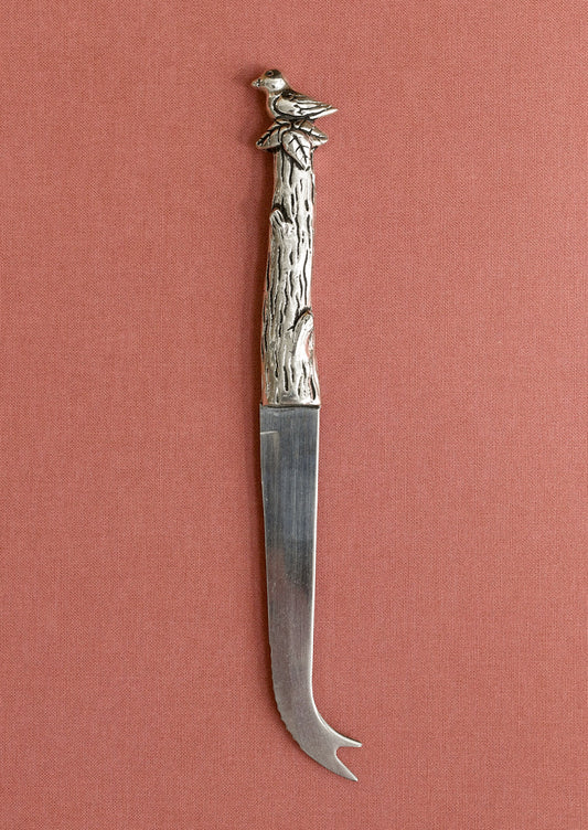 Decorative knife with a bird and branch handle on a pink background