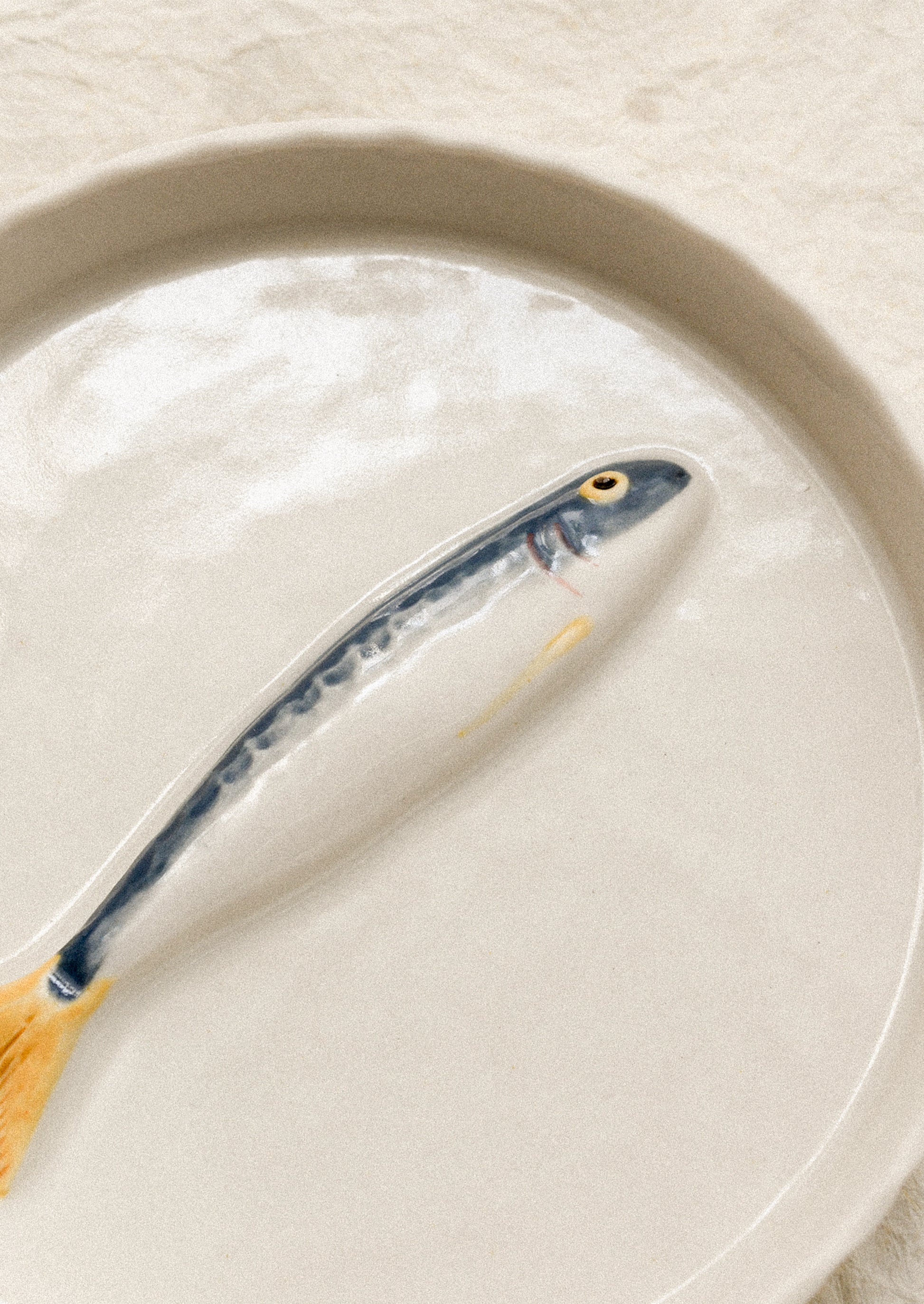 Ceramic fish-shaped object on a round plate with a plain background