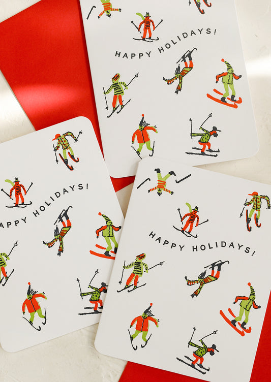 Set of Christmas cards with skier illustrations and 'Happy Holidays!' text on a white background.