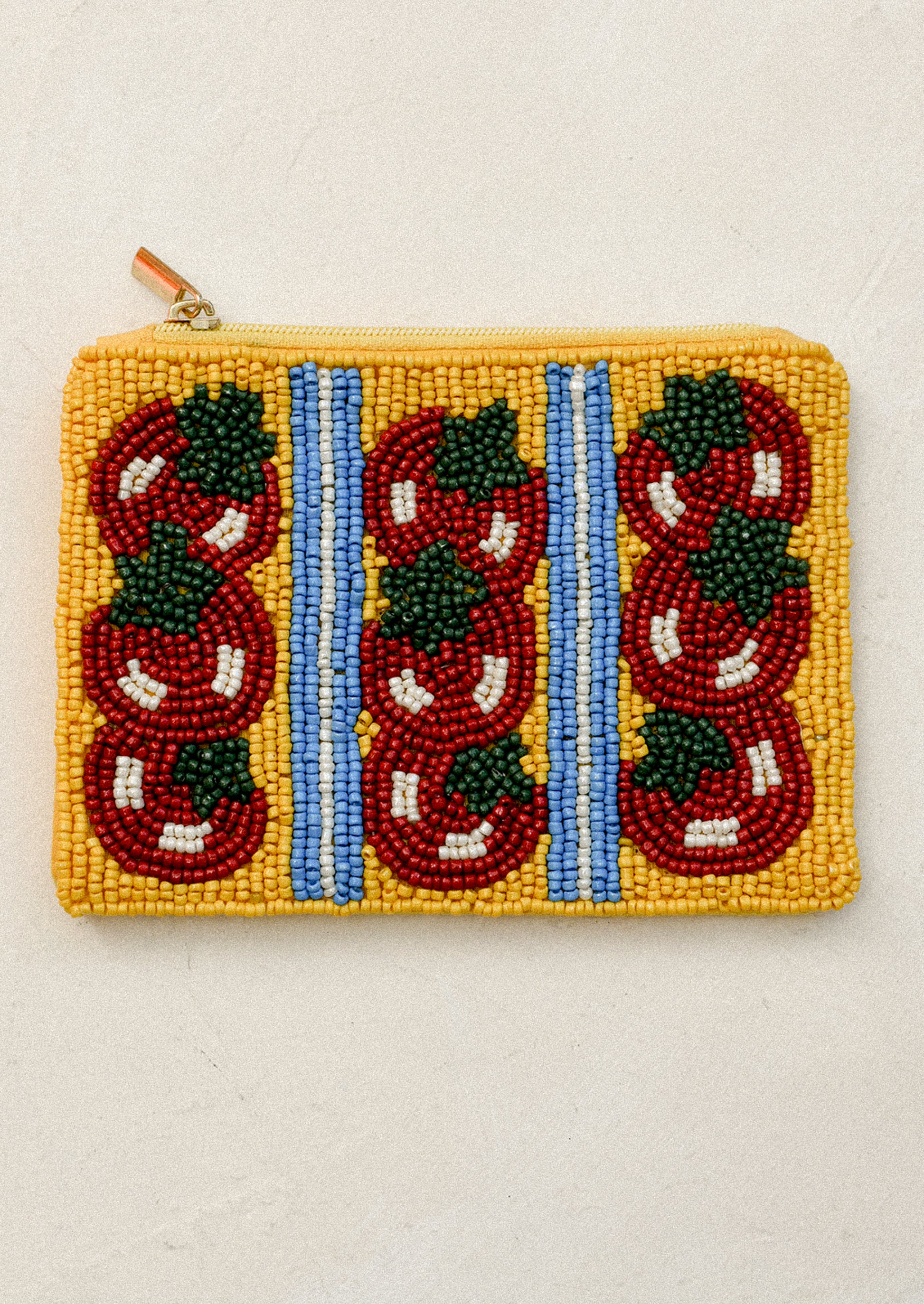 Beaded pouch with red tomato patterns on a yellow background.