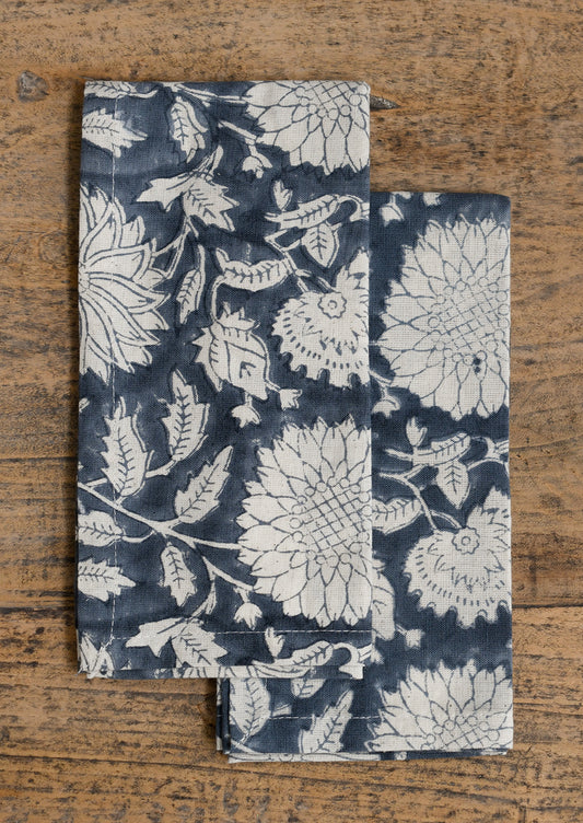 A pair of floral patterned napkins in steel blue and white.