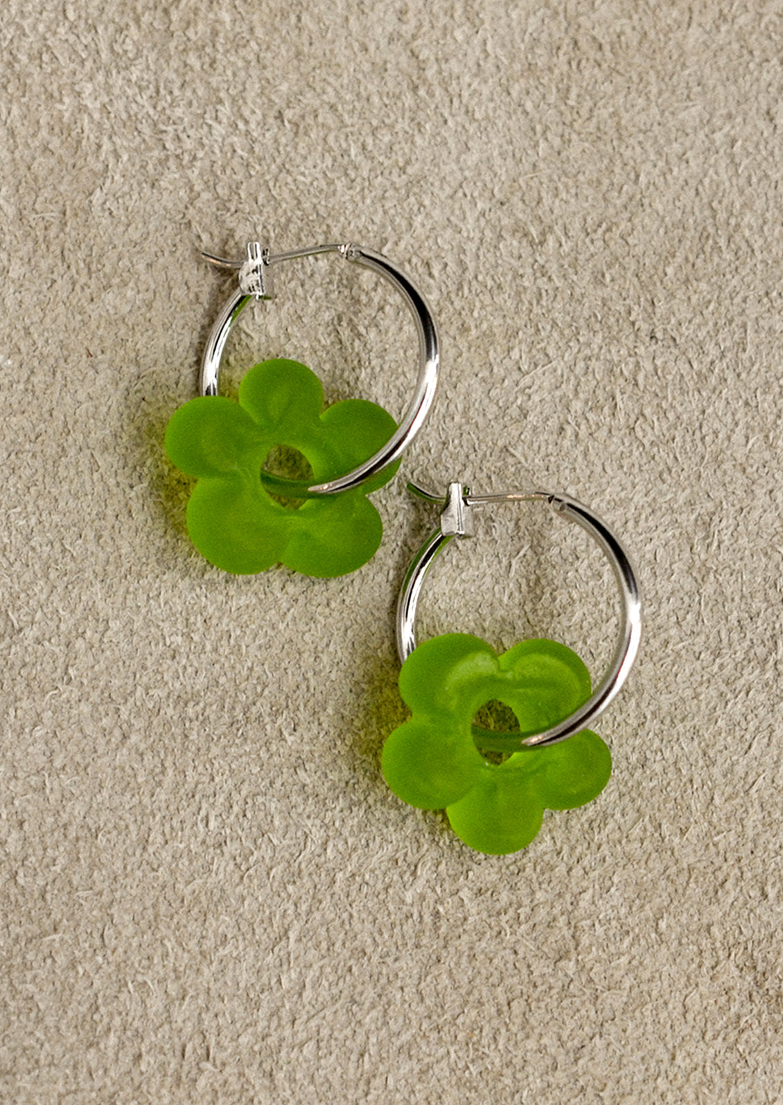 A pair of silver hoop earrings with floral Murano glass accents, displayed against a white background.