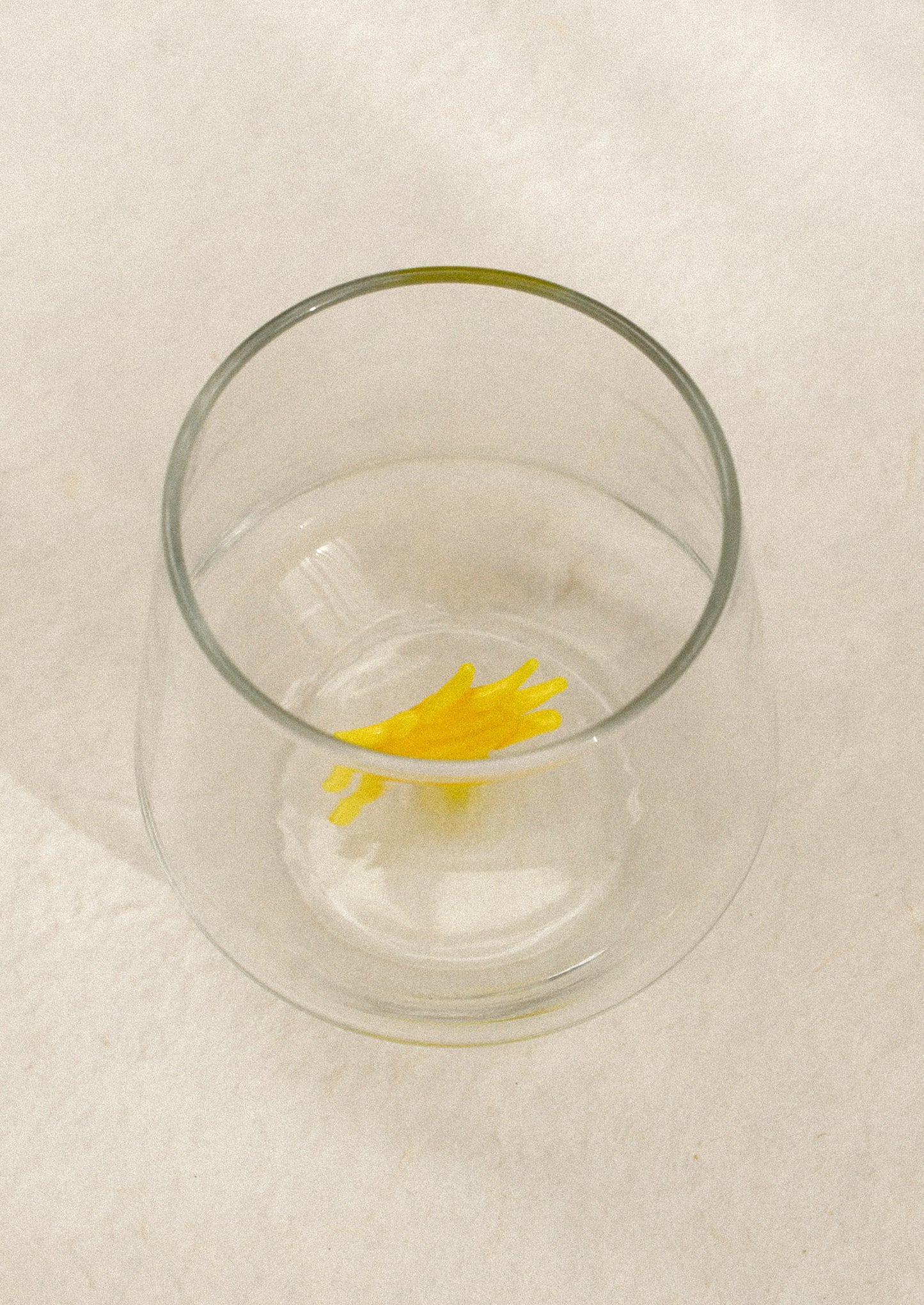 Clear glass with a yellow sun-shaped object on the inside.