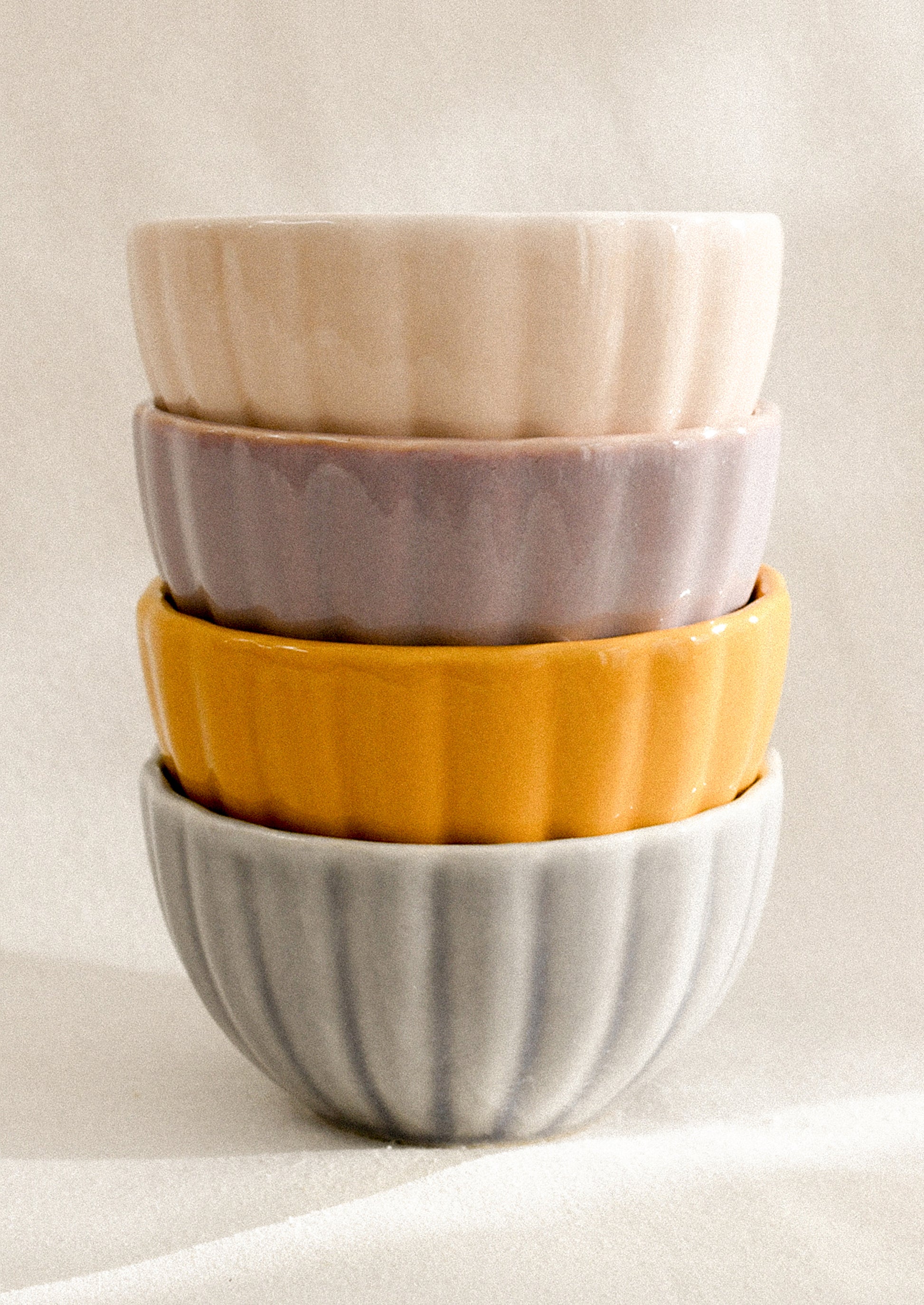 A stack of colorful ceramic bowls with ribbed texture.