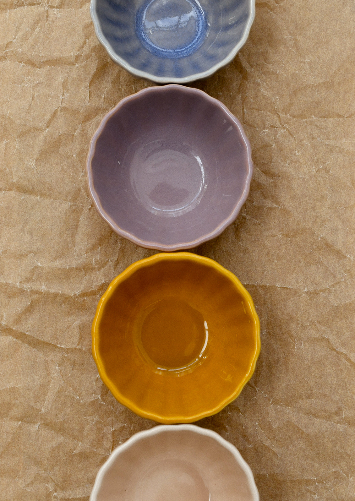 A row of colorful ceramic bowls with ribbed texture.