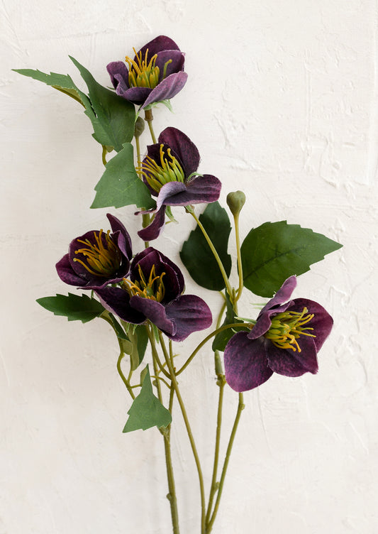 Artificial purple flowers with green leaves on a white background