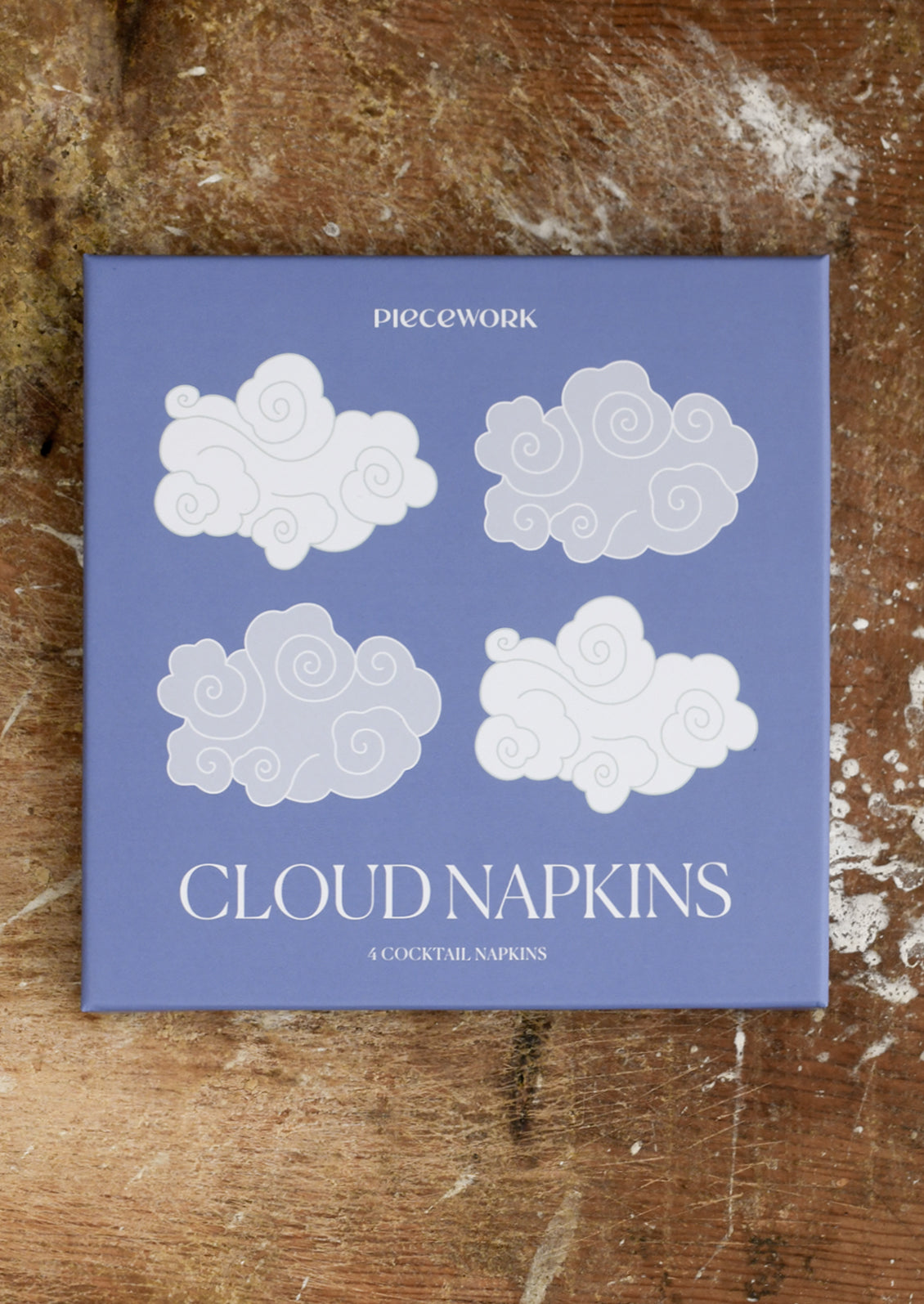 Pack of cloud-shaped napkins on a wooden surface