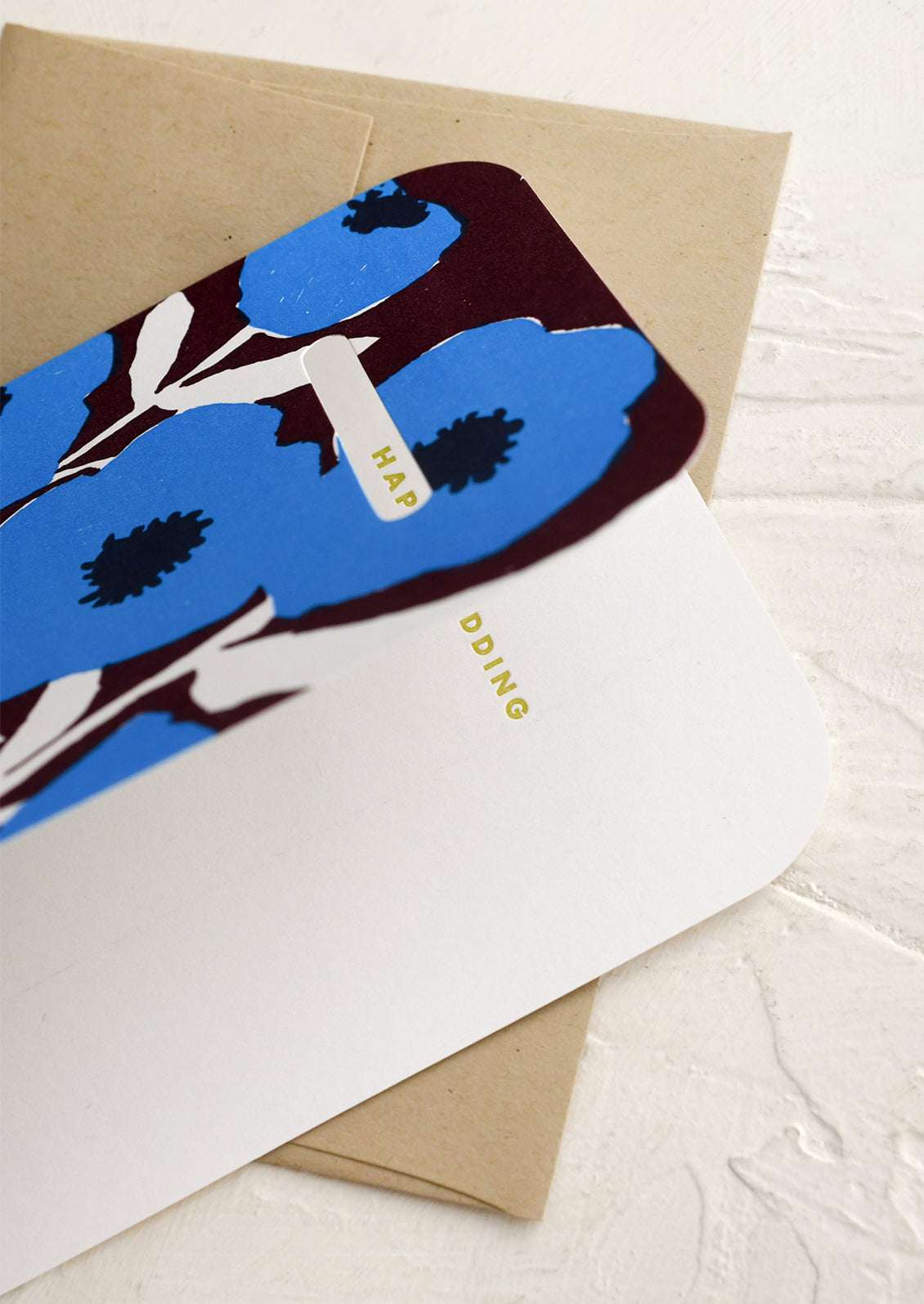 Greeting card with blue floral design and envelope on a white surface