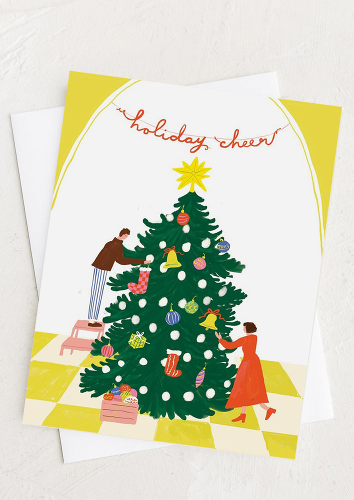 A card with illustration of a man and woman decorations a christmas tree.