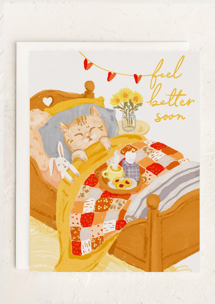 A card with illustration of cat in bed, text reads "Feel better soon".