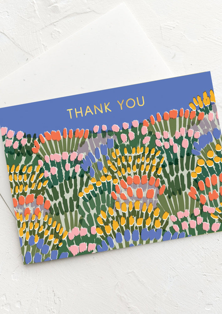 A blue card with allover flower print reading "THANK YOU".