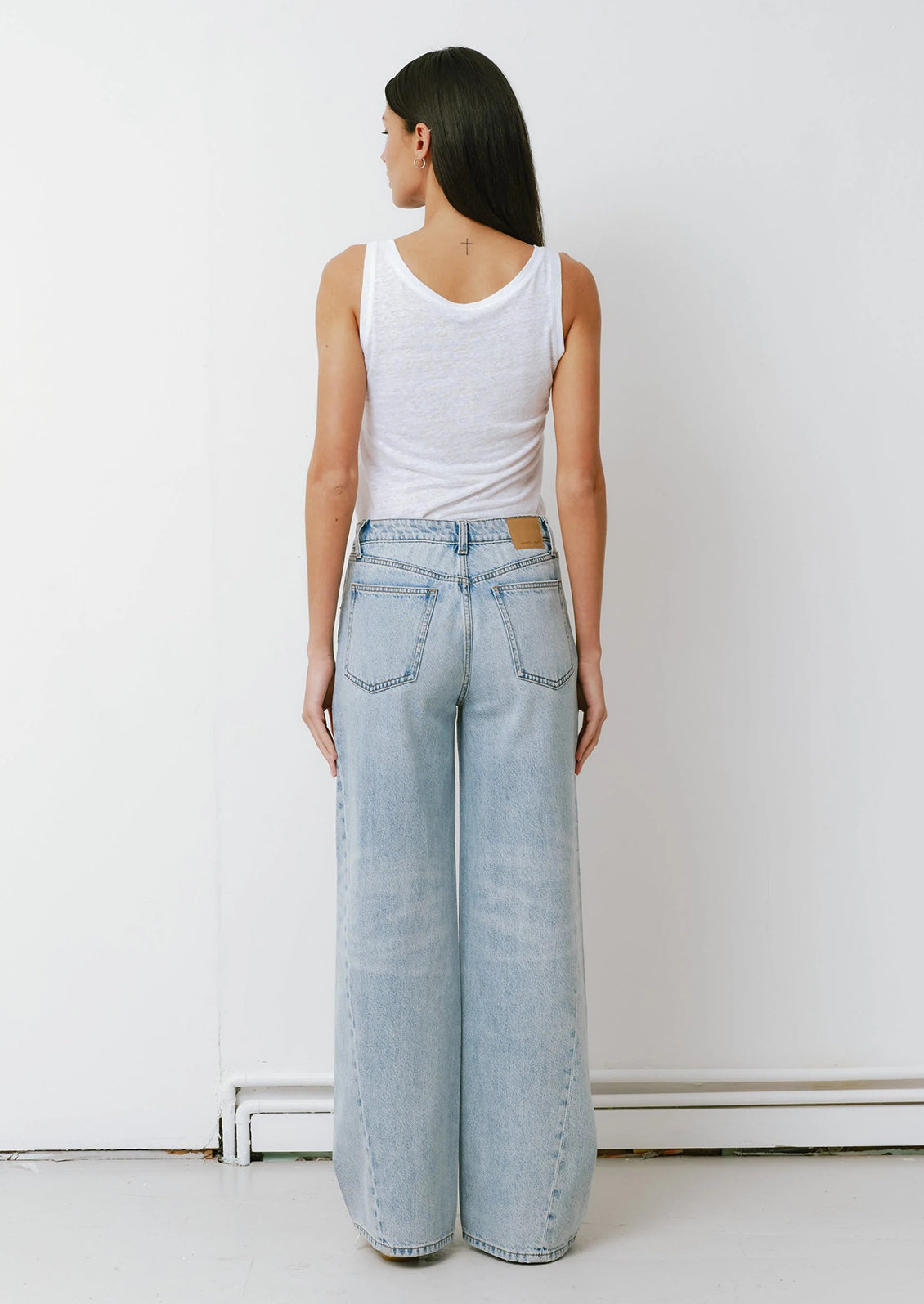 A woman wearing a pair of slouchy wide leg jeans in a light blue denim.