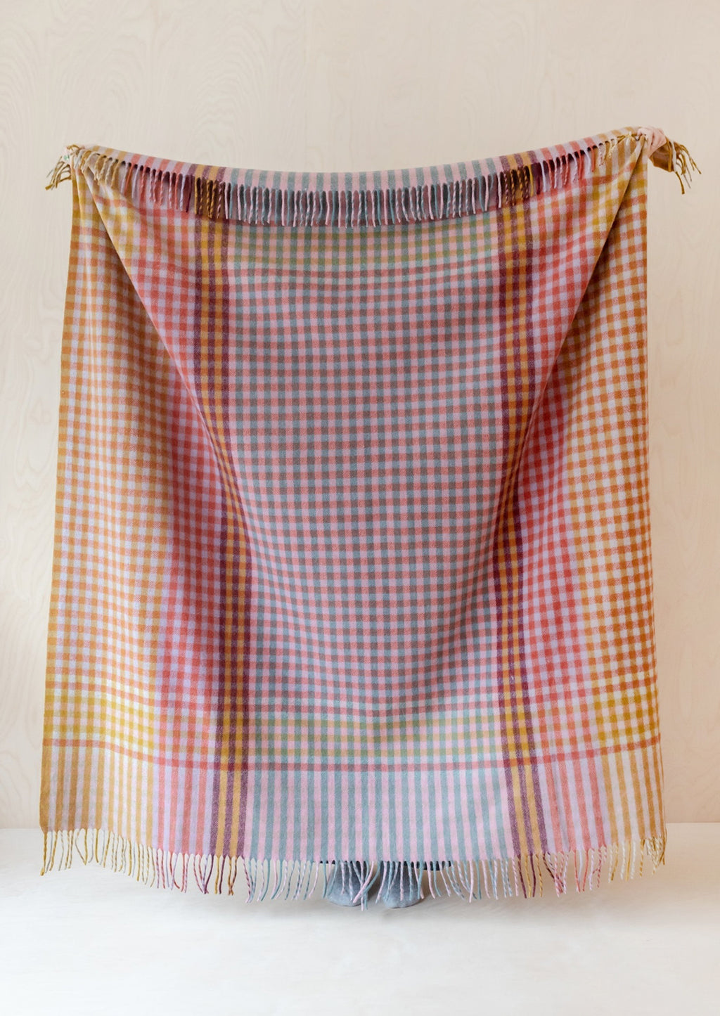 1: A colorful gingham check blanket in tones of lilac, magenta, and yellow.