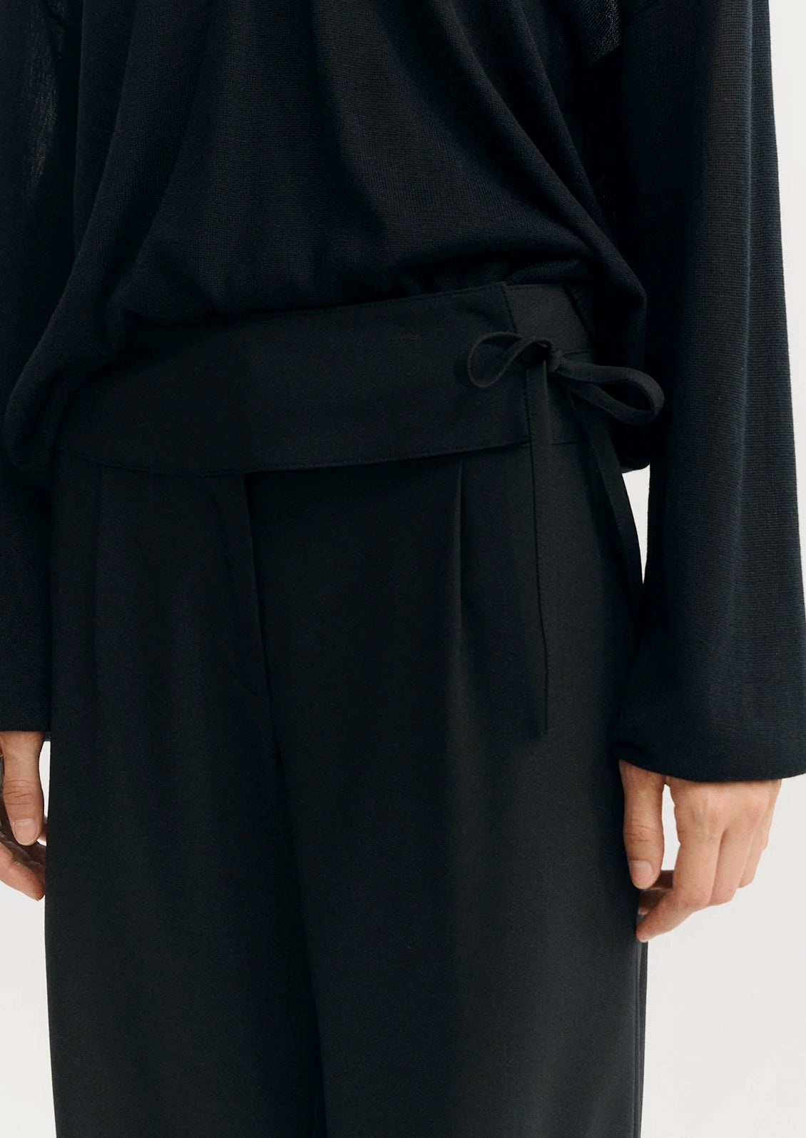 A person wearing a pair of black dress pants.