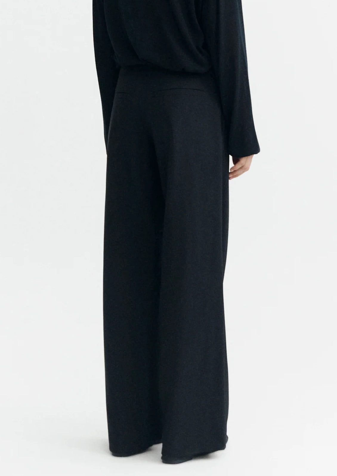 A person wearing a pair of black dress pants.