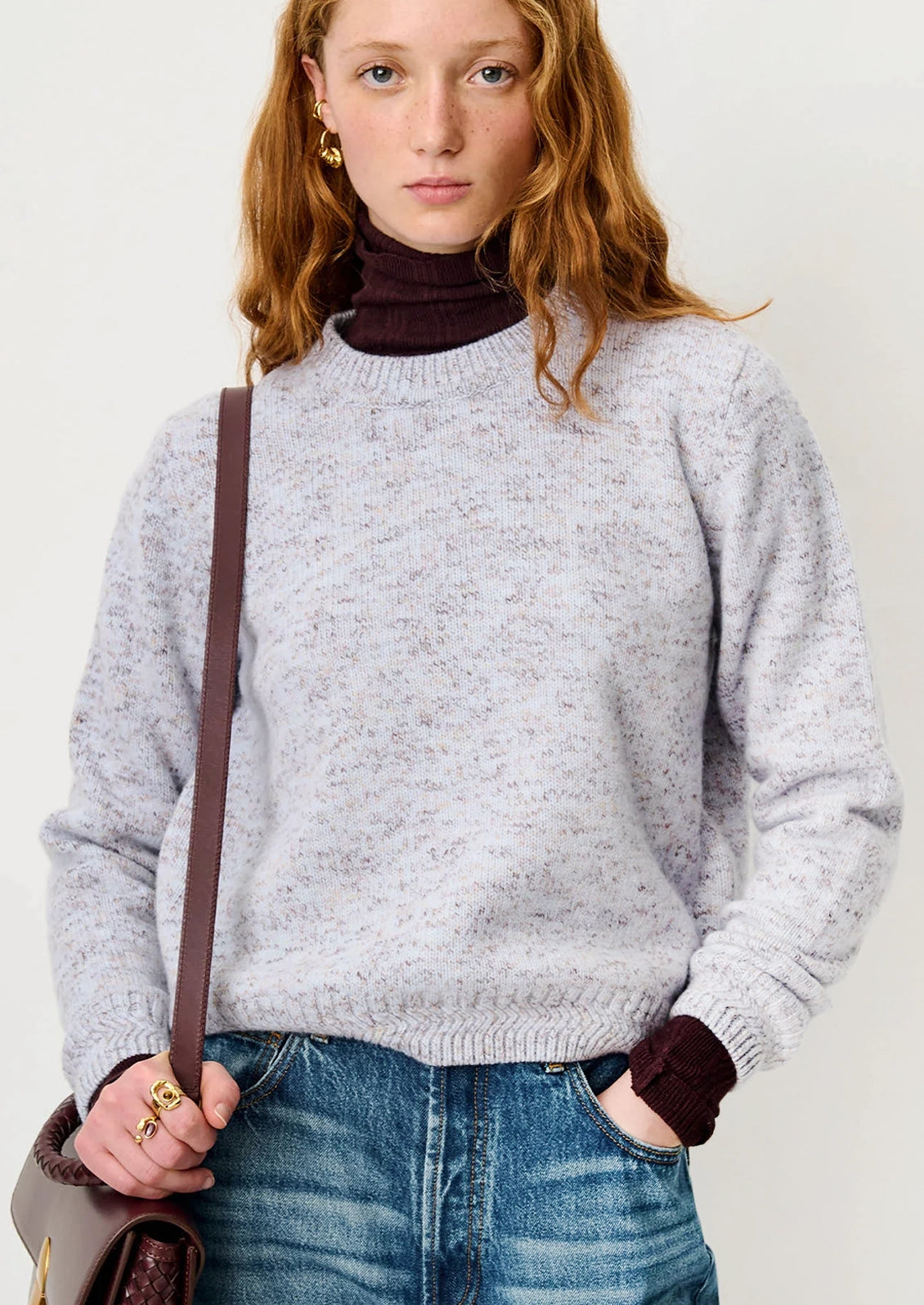 A woman wearing a wool sweater in periwinkle yarn mix.