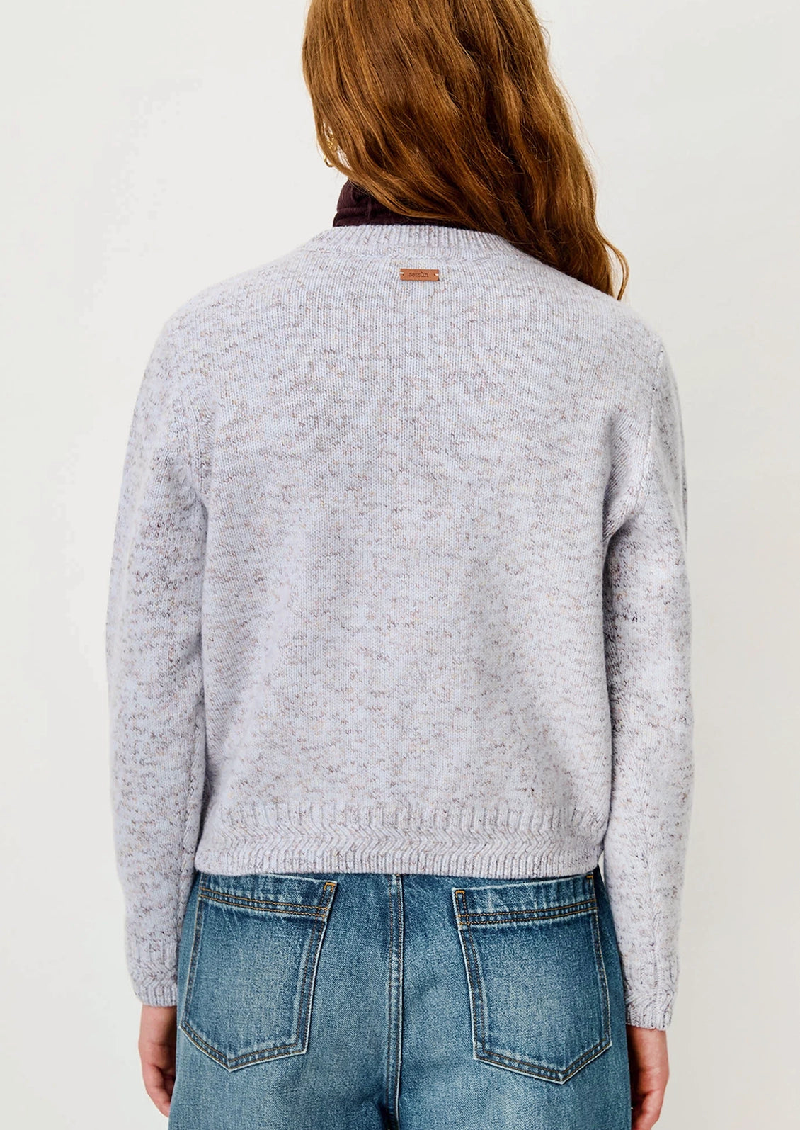 A woman wearing a wool sweater in periwinkle yarn mix.