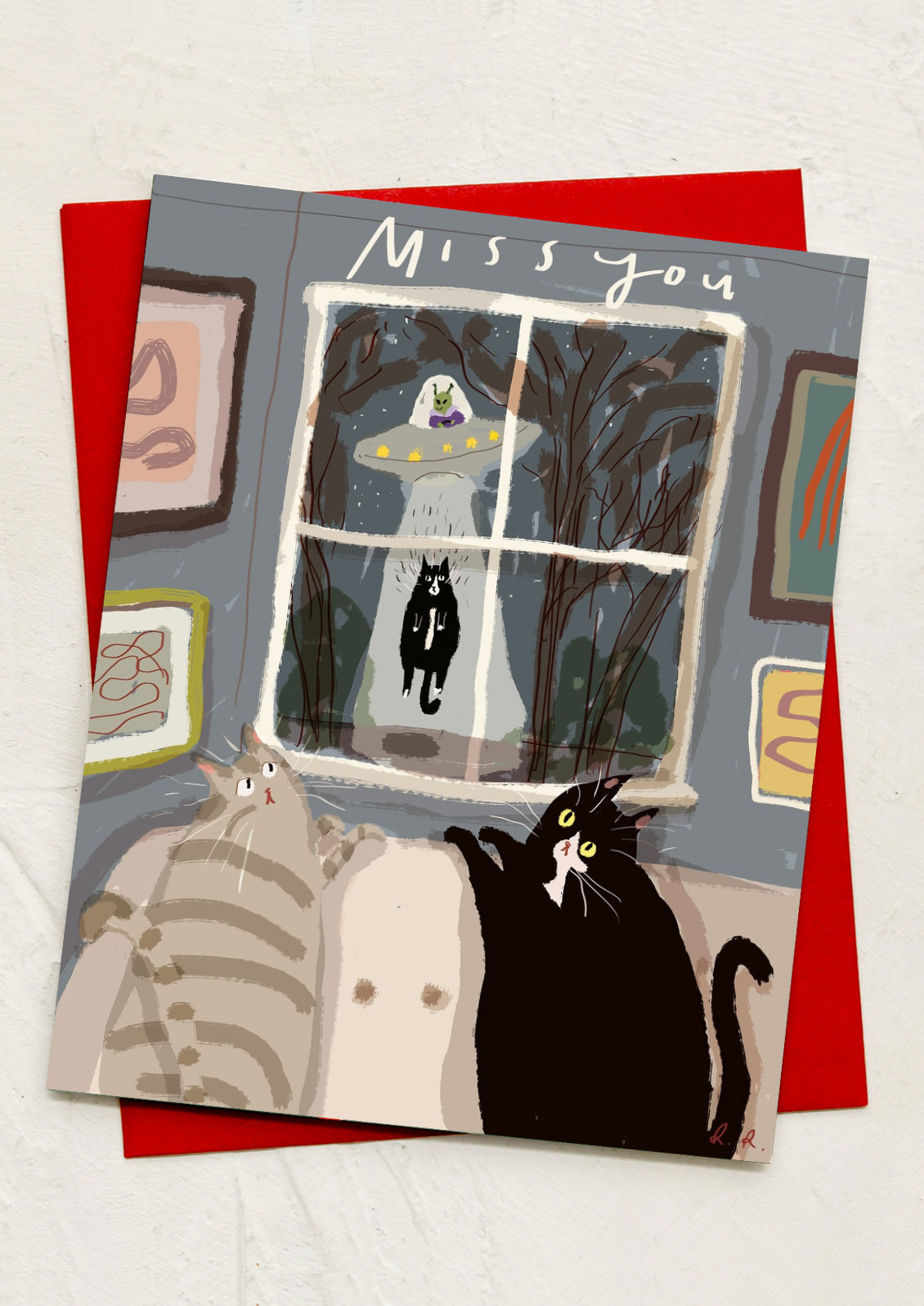 A greeting card with illustration of cats watching an alien abduction, text reads "miss you".