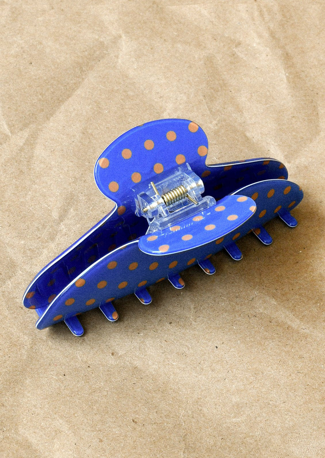 A cobalt blue hair claw with a brown polka dot pattern.