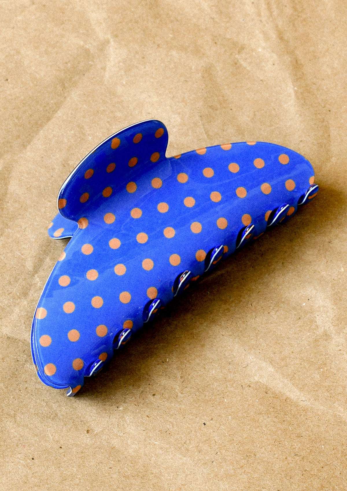 A cobalt blue hair claw with a brown polka dot pattern.