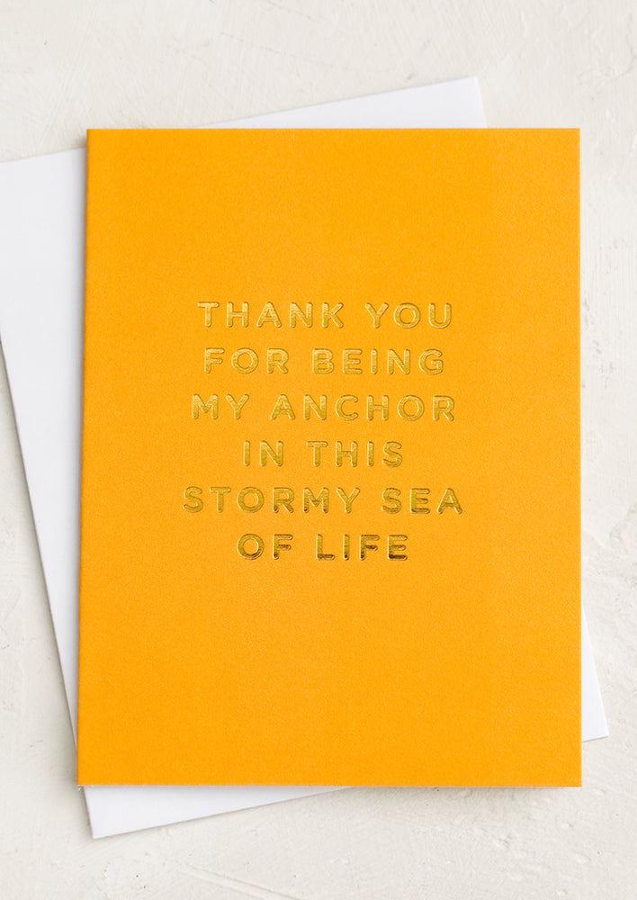 A yellow greeting card reading "Thanks for being my anchor in this stormy sea of life".