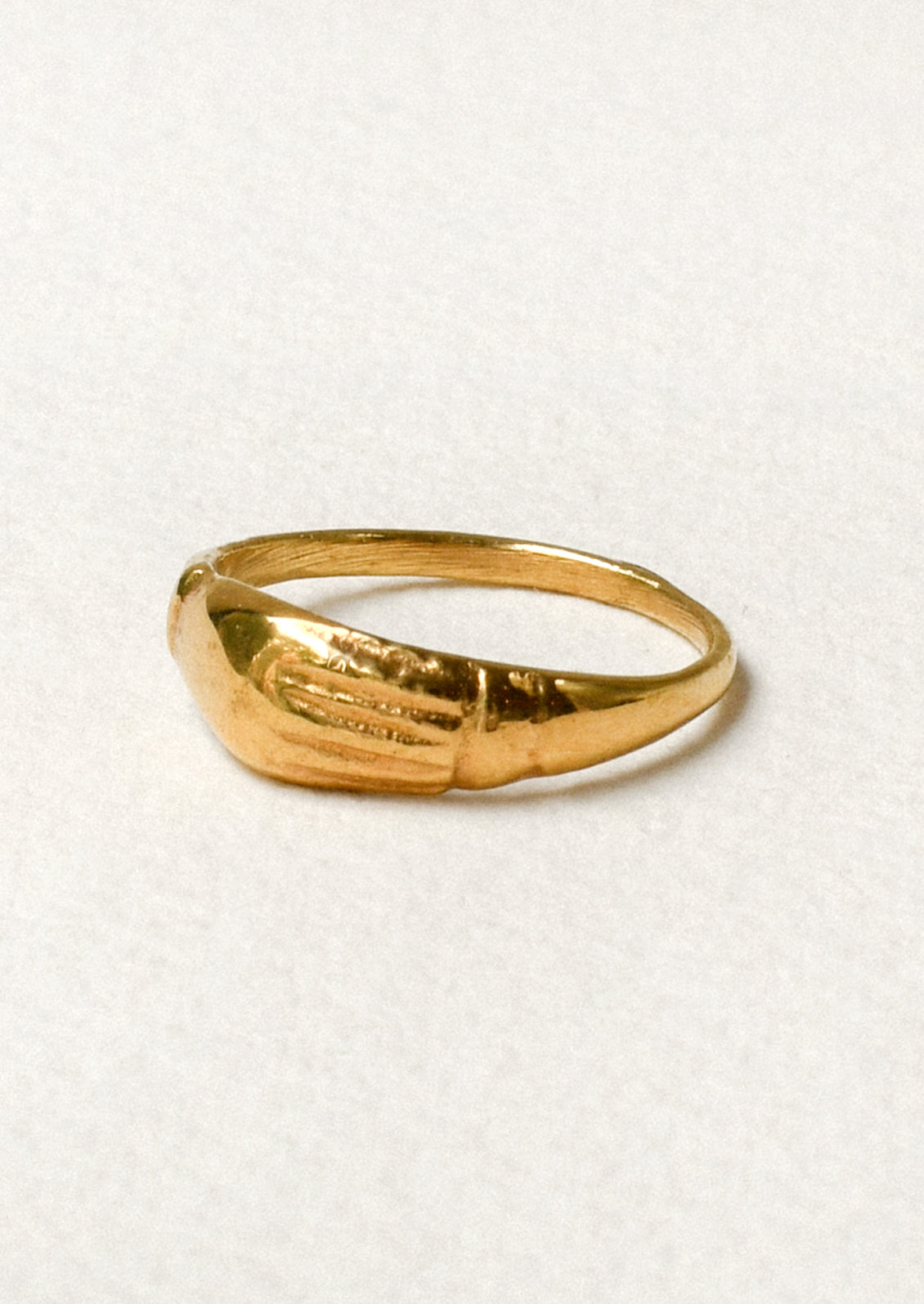 Side view of a gold ring with a unique engraved design on the front.