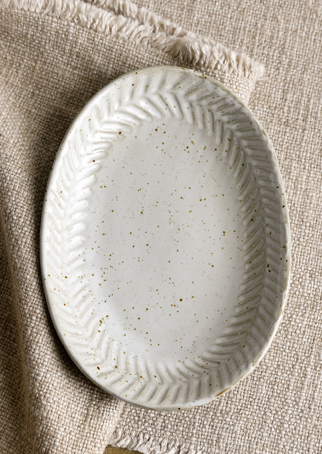 Satin Grey Speckle: A ceramic tray in oval shape in speckled gray glaze.