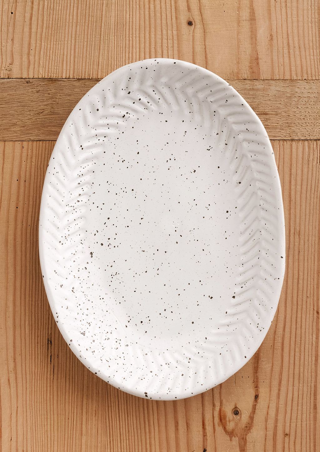 Matte White Speckle: A ceramic tray in oval shape in speckled bright white glaze.