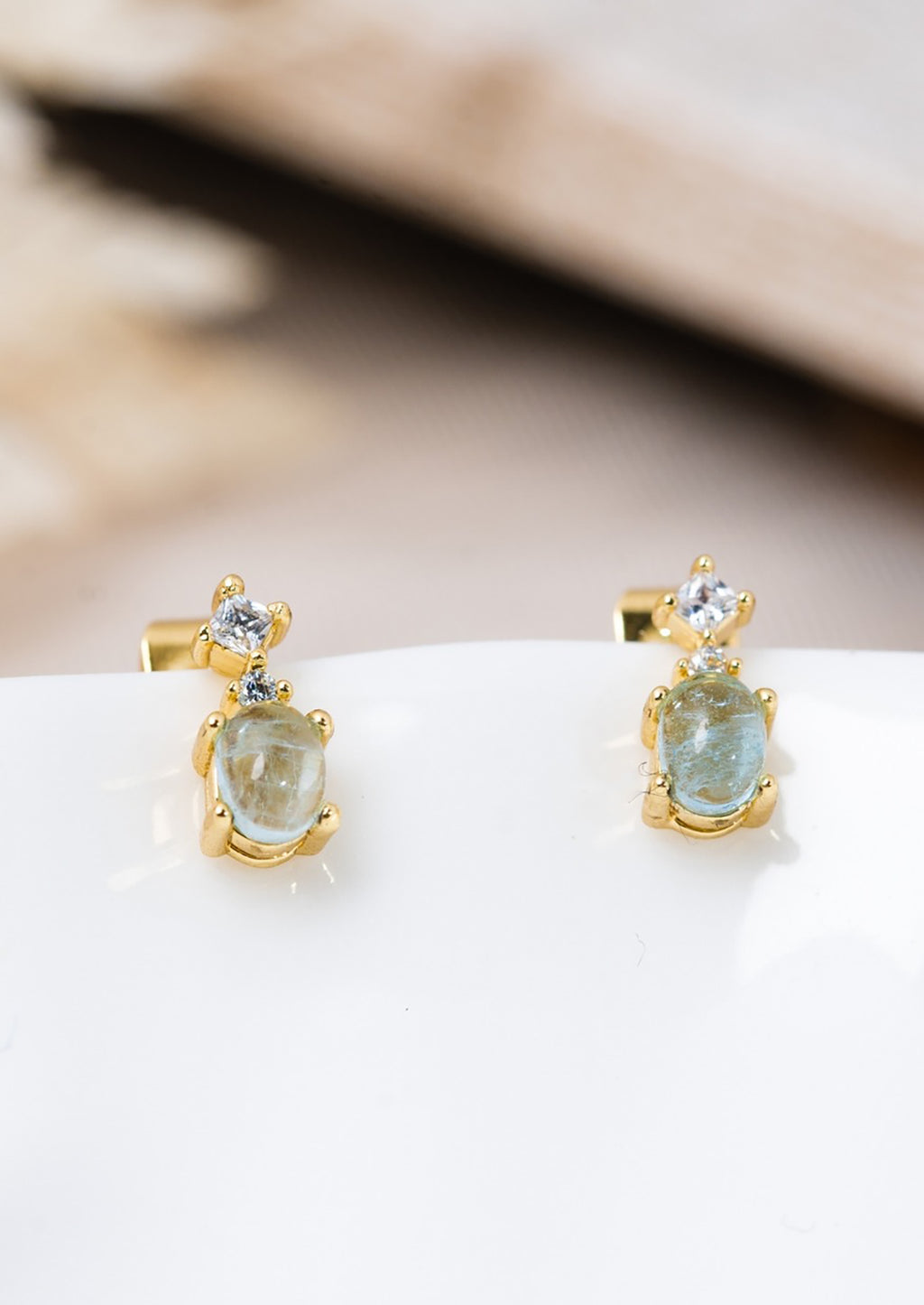 Large: A pair of bigger aquamarine stud earrings in gold with crystal detail.